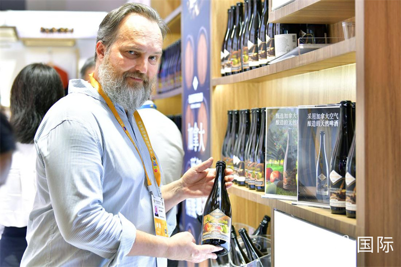 一名展商正在展示产自加拿大的苹果啤酒。人民网记者 任峰涛摄